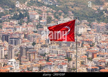 Mit türkischer Flagge auf einem Flaggenmast, mit Stadtentwicklung im Hintergrund, Alanya, Türkei Stockfoto