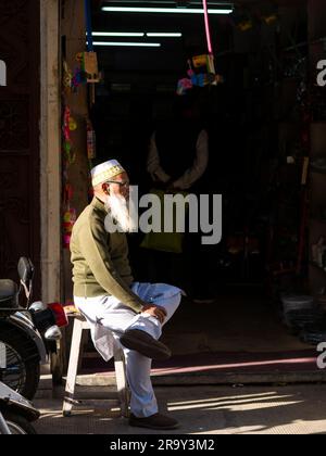 Udaipur, Indien - 29. Dezember 2022: Unidentifizierter moslemischer Ladenverkäufer, der gut auf dem lokalen Markt in Udaipur, Haathipol, verkauft. Stockfoto