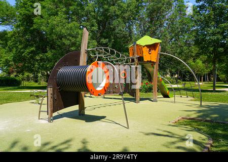 Spielplatzausstattung auf grünem Gummiboden im Parc des Bienfaites („Bienfaites Park“) von Brie Comte Robert in der Nähe von Paris, Frankreich Stockfoto