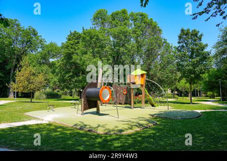 Spielplatzausstattung auf grünem Gummiboden im Parc des Bienfaites („Bienfaites Park“) von Brie Comte Robert in der Nähe von Paris, Frankreich Stockfoto