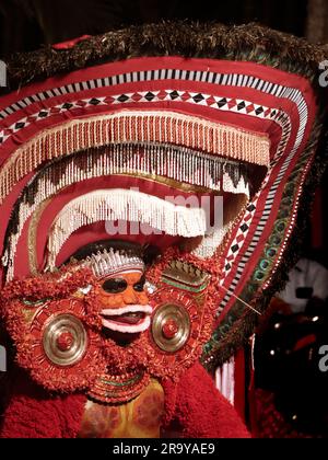 theyyam, eine beliebte Kunstform der Gottesdienste, die in kerala praktiziert wird, von einem Künstler in einem traditionellen Kostüm während des Tempelfestivals als Ritual aufgeführt Stockfoto