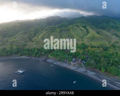 Wolken treiben über die abgelegene vulkanische Insel Sangeang, während sie aus der beeindruckenden Meereslandschaft in der Nähe des Komodo-Nationalparks, Indonesien, aufsteigt. Stockfoto