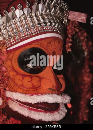 Ein Porträt eines Theyyam-Künstlers aus der Nahaufnahme, dekoriert mit Gesichtsausdruck und Ornamenten für Leistung in einem traditionellen hinduistischen Stil Stockfoto