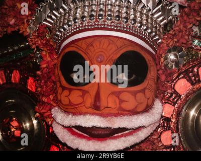 Ein Porträt eines Theyyam-Künstlers aus der Nahaufnahme, dekoriert mit Gesichtsausdruck und Ornamenten für Leistung in einem traditionellen hinduistischen Stil Stockfoto