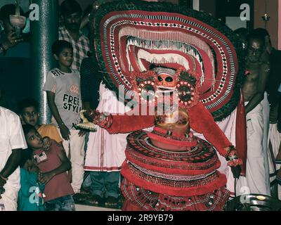 theyyam, eine beliebte Kunstform der Gottesdienste, die in kerala praktiziert wird, von einem Künstler in einem traditionellen Kostüm während des Tempelfestivals als Ritual aufgeführt Stockfoto