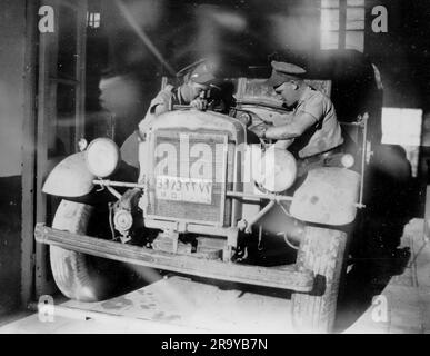 Ein britisches Militärfahrzeug in einem Mechanikschuppen in Palästina, übersehen von zwei Militärmechanikern. Palästina, c1930. Dies ist ein Foto aus einem Album, das hauptsächlich Schnappschüsse während der Besetzung Palästinas durch die britische Armee enthält, mit Fotos aus Palästina und Großbritannien, darunter Devil's Jump bei Churt in Surrey und Devil's Punch Bowl. Das Training scheint im Hursley Camp bei Winchester zu sein. Zwischen 1920 und 1948 verwaltete Großbritannien Palästina im Namen des Völkerbundes, ein Zeitraum, der als "britisches Mandat" bezeichnet wird. Stockfoto