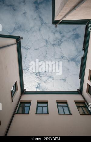 Faszinierende Aussicht vom unteren Ende des Gebäudes bis zum Gipfel, wo Sie die Umrisse des Gebäudes und den Himmel mit Wolken sehen können. Stockfoto