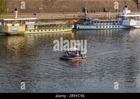 Touristische Unterhaltung an der Elbe bei Dresden. Partyfloß im Vordergrund, dahinter White Fleet Dresden, historischer Raddampfer Pillnitz. Mit neun historischen Raddampfern befindet sich hier die älteste und größte Raddampfflotte der Welt. Die Elbe wird zwischen Diesbar-Seußlitz und Bad Schandau befahren. Dresden, Deutschland. Dresden an der Elbe Stockfoto