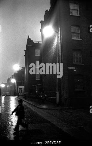 East End London 1970s UK. Brick Lane und die Kreuzung Sheba Street, ein Teenager spaziert vorbei an den viktorianischen Slum Wohnblocks. Peabody Estate Tower Hamlets, London, England 1976 70er Jahre HOMER SYKES Stockfoto