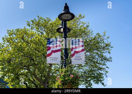 Stone Harbor, NJ - 25. Mai 2023: „Willkommen in Stone Harbor, The Seashore at its Best!“ Banner hängen mit Blumenkörben von einem Lampenpfahl in der Stadt Stockfoto