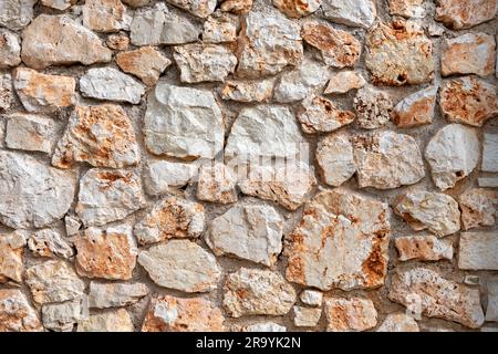 Eine Wand aus bearbeiteten Steinen. Stockfoto