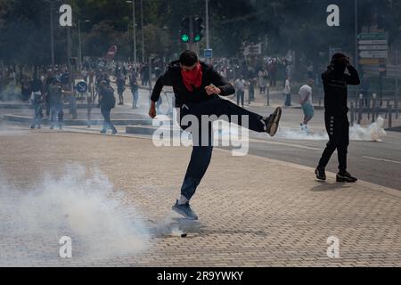 Nanterre, Frankreich. 29. Juni 2023. Ein Mann wirft einen Tränengaskanister zurück, der von Sicherheitskräften während eines Protests in Nanterre, einer Stadt am westlichen Stadtrand von Paris, Frankreich, am 29. Juni 2023 abgefeuert wurde. Die französischen Sicherheitskräfte setzten am Donnerstag Tränengas ein, als sie während einer Kundgebung mit Demonstranten zusammenstießen, die durch die tödliche Schießerei auf Nahel M, einen 17-jährigen Teenager, ausgelöst wurde, die am Dienstag von einem Polizeibeamten während eines Verkehrsstopps durchgeführt wurde. Kredit: Aurelien Morissard/Xinhua/Alamy Live News Stockfoto