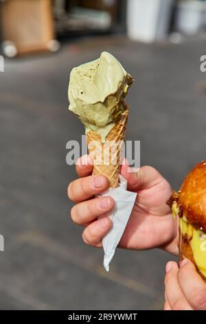 Eiskegel mit Minzpistazienfarbe in der Stadt. Sommerliche kalte Erfrischung. Köstliches Essen. Stockfoto