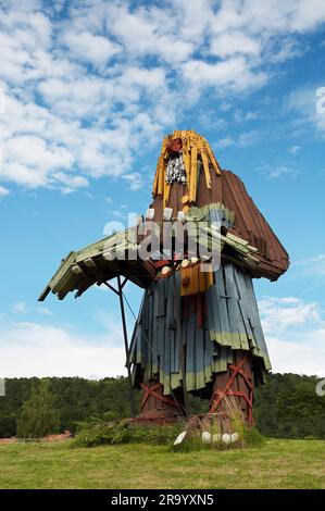 Niedriger Winkel Blick auf eine riesige hölzerne Trollskulptur unter bewölktem Himmel. Huskvarna, Schweden. Stockfoto
