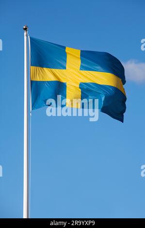 Blick auf die schwedische Flagge, die vor klarem blauen Himmel flattert Stockfoto