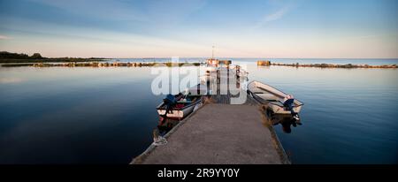 Boote am Pier in der ruhigen und friedlichen Ostsee vor klarem Himmel, Insel Gotland, Schweden Stockfoto