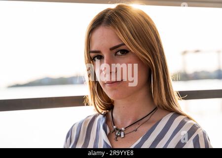 Porträt einer jungen, wunderschönen Frau, die auf einem Boot sitzt und in den Sommerferien auf einem Fluss segelt Stockfoto