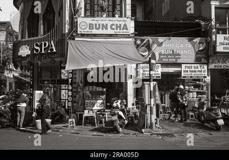 Die Leute durchstöbern kleine Restaurants und Geschäfte in der Altstadt, Hanoi, Vietnam. Stockfoto