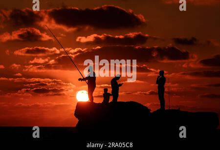 Gaza, Palästina. 29. Juni 2023. Die Palästinenser beobachten den Sonnenuntergang am Strand im Mittelmeer am zweiten Tag des Urlaubs in Eid al-Adha. (Foto: Ahmed Zakot/SOPA Images/Sipa USA) Guthaben: SIPA USA/Alamy Live News Stockfoto