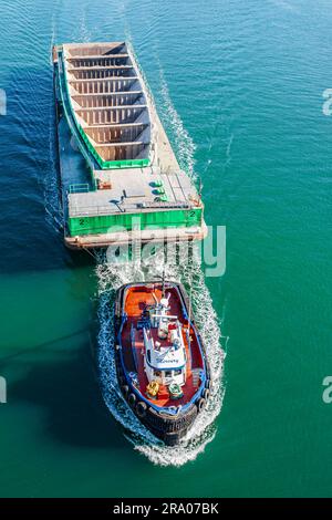 Schleppschiff mit Fracht auf dem Wasser, Luftaufnahme. Schlepper, der leeres Schiff im Hafen von Vancouver, BC, zieht – März 23,2023. Ein Reisefoto, niemand Stockfoto