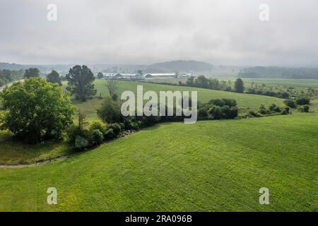 Luftaufnahme eines Bauernhofs und einer Reihe von Bäumen in der Stadt Wallkill, New York, an einem nebligen Morgen. Stockfoto