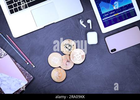 Bitcoins, Schreibwaren und verschiedene Geräte auf grauem Tisch, flach liegend Stockfoto