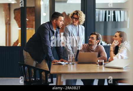 Team von Fachleuten, die ein Meeting in einer digitalen Marketingagentur halten. Geschäftsleute diskutieren ein Projekt in einem Büro. Teamarbeit und Zusammenarbeit in Stockfoto