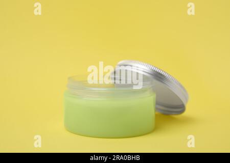 Glas Vaseline auf gelbem Hintergrund Stockfoto