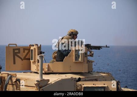 Südchinesisches Meer (18. April 2023) – USA Marinekorps-Staff Sergeant Gordon Adams, TOP, ein Maschinenschütze, dem Landungsteam 2/4, 13. Marine Expeditionary Unit zugeteilt, beobachtet als US Navy Gunners Mate, dritte Klasse Royce Miguel, der der Amphibienladerampe USS John P. Murtha (LPD 26) zugeteilt ist, feuert ein M240B-mm-Maschinengewehr ab, das am 18. April 2023 an einem Joint Light Tactical Vehicle Shooting an Bord der John P. Murtha befestigt ist. Die 13. MEU wird von der Makin Island Amphibious Ready Group angeflogen, die sich aus dem Amphibienschiff USS Makin Island (LHD 8) und der Amphibienschiff TRA zusammensetzt Stockfoto