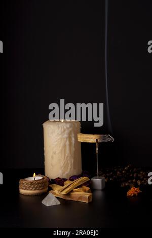 Palo santo (heiliger Stab) mit brennenden Kerzen und Japa mala auf schwarzem Hintergrund Stockfoto
