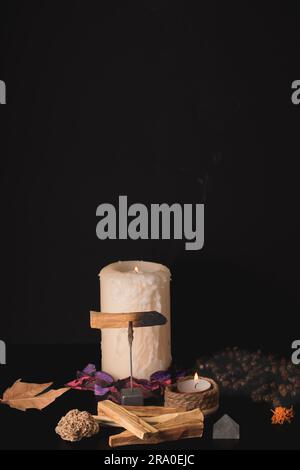 Palo santo (heiliger Stab) mit brennenden Kerzen und Japa mala auf schwarzem Hintergrund Stockfoto
