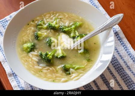 Suppe mit Brokkoli, Kohl, Reis, Nudeln und Butter in warme Hühnerbrühe Stockfoto