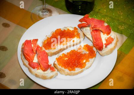 Toast mit rotem Kaviar und Lachs aus der russischen Kamtschatka auf einem weißen Keramik Teller Stockfoto