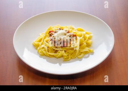 Bandnudeln mit Bolognese Ragout mit Parmesan, in einem weißen Teller Stockfoto
