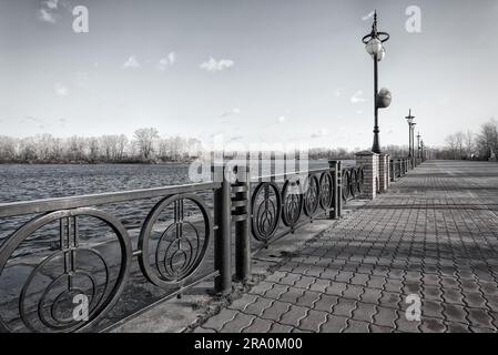 Fußweg entlang des Dnieper River im Obolon Bezirk Kiew, Ukraine. Weiche Sonne an einem kalten Wintermorgen Stockfoto