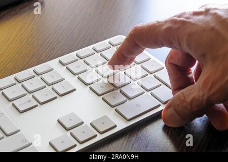 Ein senior woman ist die numerische Tastatur seines Computers verwenden. Stockfoto