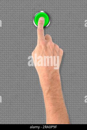 Ein Mann, eine große grüne Start-Stop-Alarm-Taste mit dem Finger drücken Stockfoto