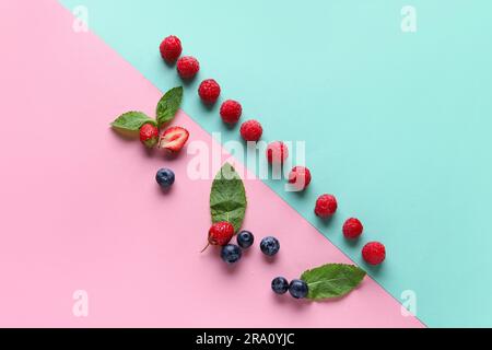 Frische Himbeeren, Heidelbeeren und Erdbeeren auf farbenfrohem Hintergrund Stockfoto