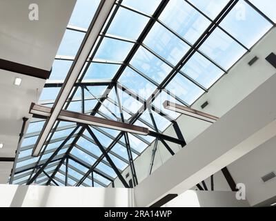 Beleuchtung und Lüftungsanlage in langer Linie an der Decke des Industriegebäudes. Ausstellungshalle. Deckenfabrikbau Stockfoto
