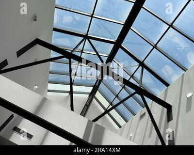 Beleuchtung und Lüftungsanlage in langer Linie an der Decke des Industriegebäudes. Ausstellungshalle. Deckenfabrikbau Stockfoto