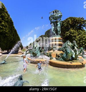 FRANKREICH. PARIS (75) 6TH. BEZIRK. LUXEMBURGER GARTEN. KINDER SPIELEN WÄHREND DER HITZEWELLE BEI 38°C IM BRUNNEN DER VIER TEILE DER WELT IM G Stockfoto