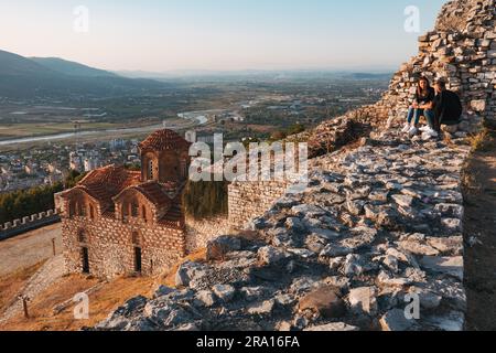 Ein Paar entspannt sich auf einer Mauer in der Nähe der Heiligen Dreifaltigkeitskirche, einer byzantinischen Kirche im Beratschloss aus dem 13. Jahrhundert, Albanien Stockfoto