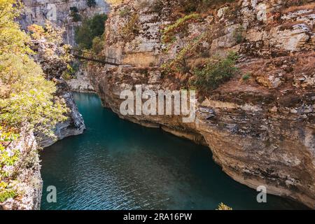 Eine alte Fußgängerbrücke, die den Fluss Osum im Osumi Canyon, Albanien, überspannt Stockfoto