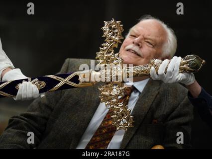 Der Schwertdesigner Mark Dennis sieht das Elizabeth-Schwert, das Teil der Honours of Scotland - Schottlands Kronjuwelen - sein wird, während es in der Powderhall Bronze Foundry in Edinburgh enthüllt wird. Das Schwert wird König Karl III. Zusammen mit der Krone und dem Zepter während des Gottesdienstes von Thanksgiving in der St. Giles Cathedral in Edinburgh überreicht. Foto: Donnerstag, 29. Juni 2023. Stockfoto