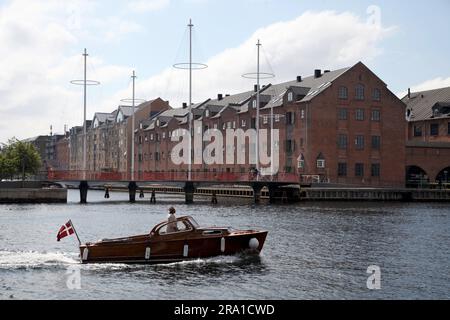 Kopenhagen, Dänemark. 28. Juni 2023. Ein Mann segelt mit seinem Boot an der Cirkelbroen (Circle Bridge) vorbei, entworfen vom dänisch-isländischen Künstler Olafur Eliasson, dessen Masten an ein Segelschiff erinnern. In den kommenden Tagen findet in Kopenhagen der 28. Weltkongress der Architekten statt. (Zu dpa 'gesundes Bauen' - wie nachhaltig kann Architektur sein?') Kredit: Steffen Trumpf/dpa/Alamy Live News Stockfoto