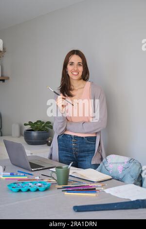 Porträt einer Künstlerin und Unternehmerin, die lächelt und in die Kamera schaut. Einzigartiger Bekleidungsdesigner. Stockfoto