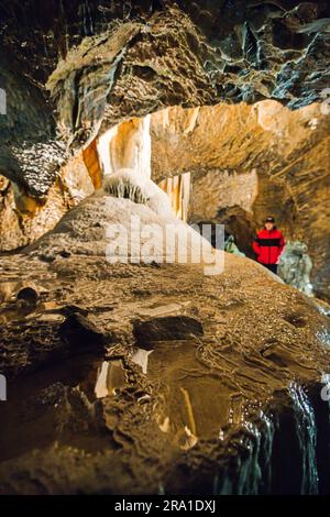 Touristen laufen in den Punkva (Punkevni) Höhlen, die mit Stalaktiten und Stalagmiten in Mährischem Karst, Tschechische Republik, geschmückt sind, 29. Juni 2023. (CTK Photo/Patrik Uhlir) Stockfoto