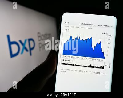 Person, die ein Smartphone mit der Webseite des US-amerikanischen Unternehmens Boston Properties Inc. Besitzt (BXP) auf dem Bildschirm vor dem Logo. Konzentrieren Sie sich auf die Mitte des Telefondisplays. Stockfoto