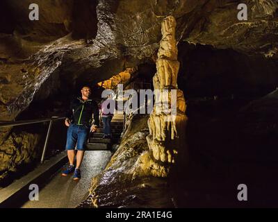 Touristen laufen in den Punkva (Punkevni) Höhlen, die mit Stalaktiten und Stalagmiten in Mährischem Karst, Tschechische Republik, geschmückt sind, 29. Juni 2023. (CTK Photo/Patrik Uhlir) Stockfoto