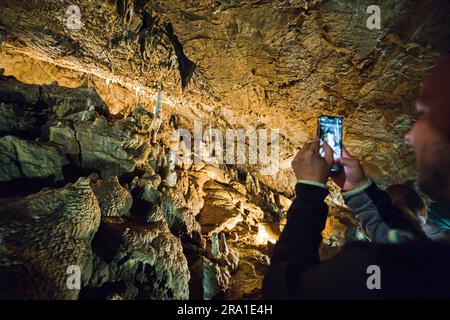 Touristen laufen in den Punkva (Punkevni) Höhlen, die mit Stalaktiten und Stalagmiten in Mährischem Karst, Tschechische Republik, geschmückt sind, 29. Juni 2023. (CTK Photo/Patrik Uhlir) Stockfoto